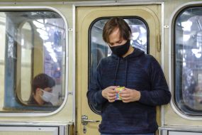 Молодой человек собирает кубик Рубика