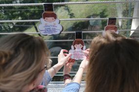 Участники акции наклеивают плакаты в форме ангелов