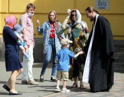 Прихожане общаются со священнослужителем возле Владимирского собора