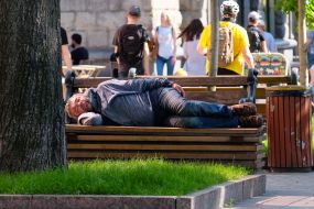 The man sleeps on a bench