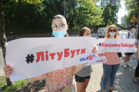 Woman holding a poster with the inscription "#Lita Be"