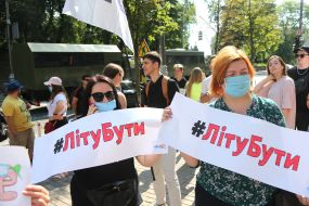 Women hold placards with the inscription "#Summer Be"