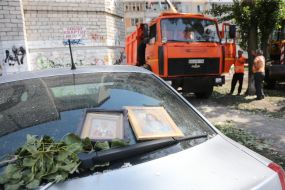 Icons on the windshield of a car near a house damaged in an explosion in Kyiv
