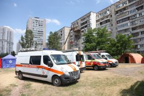 People near a house damaged in an explosion in Kyiv