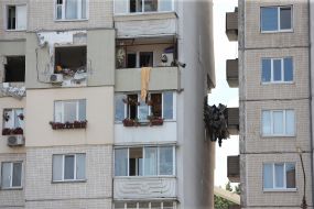 People near a house damaged in an explosion in Kyiv