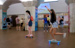 Girls ride skateboards at one of the stations of the Kyiv metro