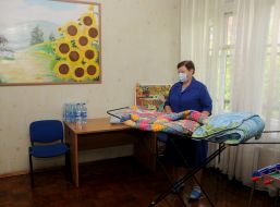 An employee of the Special Boarding School №12 in Kyiv folds blankets