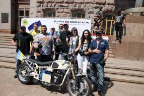 Сергій Малик фотографується біля електричного мотоцикла Dnepr Electric