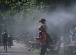 Люди возле рамки с распылителями воды