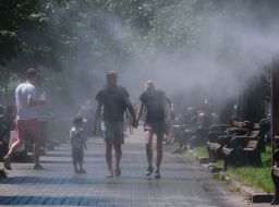 Люди возле рамки с распылителями воды