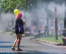 Девушка с шариком возле рамки с распылителями воды