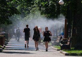 Люди возле рамки с распылителями воды