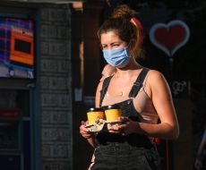 Girl in a medical mask with coffee in her hands