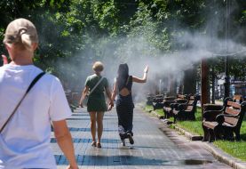 Люди возле рамки с распылителями воды