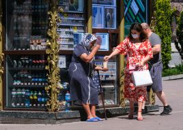 An elderly woman asks for alms