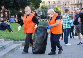Utility workers carry a garbage bag on Independence Square