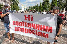 Protesters hold a poster reading "No to political repression"