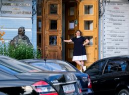 Женщина в защитной маске у входа в театр