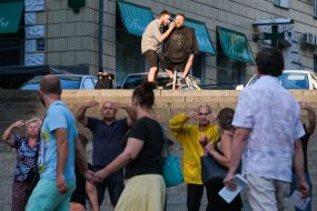 A man cuts his beard on the street