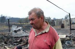 A local resident on a fire in the village of Smolyaninovo in Luhansk region