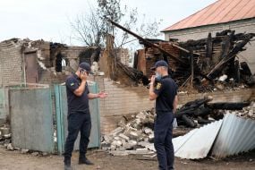 Militiamen near the houses in the village of Smolyaninovo burned down as a result of a fire