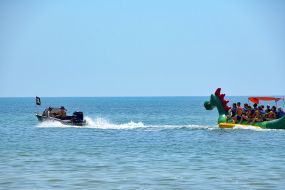 Vacationers ride on the attraction "Dragon"  in the sea