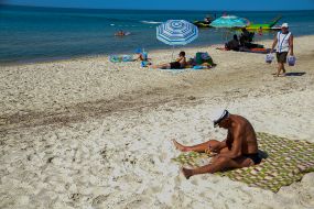 A man sunbathes on the beach