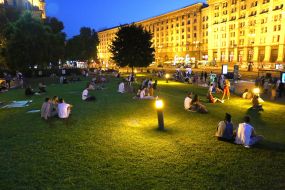 Young people are resting on the lawn on Independence Square