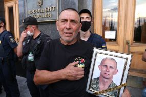 Serhiy Zhuravel holds a portrait of his son Yaroslav Zhuravel
