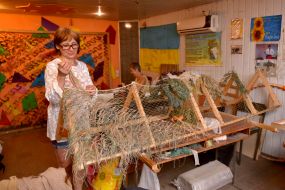 Volunteers weave camouflage suits and nets for the army