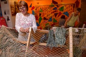 Volunteers weave camouflage suits and nets for the army