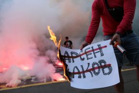 Protesters set fire to the poster