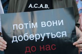 The participant of the action holds a poster