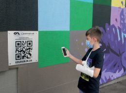 The boy scans the QR code near the smart mural