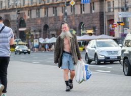 An elderly man carries packages