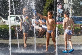 Дети играют в фонтане