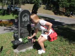 Девушка возлагает цветы к памятнику Михаилу Жизневскому