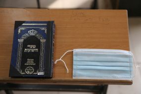 Релігійна книга та медична маска