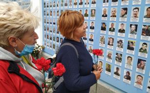 Women with flowers near the Wall of Remembrance