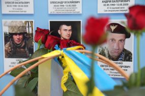 Flowers near photos of fallen soldiers on the Wall of Remembrance