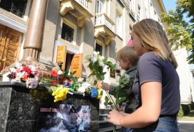 Люди несуть квіти до стін Харківського національного університету Повітряних Сил імені Кожедуба