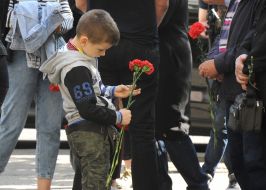 People carry flowers to the walls of the Kharkiv National University of the Air Force named after Kozhedub