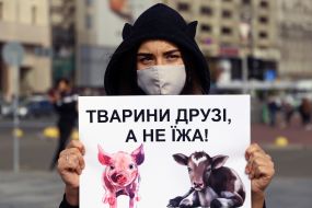 The activist holds a poster with the inscription: "Animals are friends, not food!"