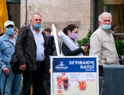 People in respiratory masks stand in line