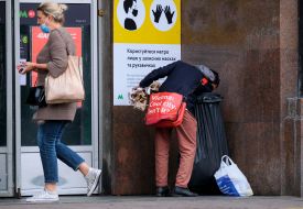 A man rummages in a trash can