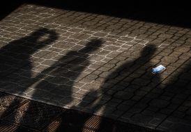 Shadows of people and respiratory mask on the floor