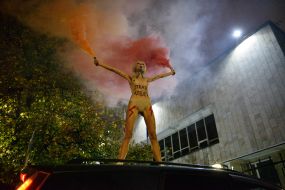 Femen activist with a fireworks display