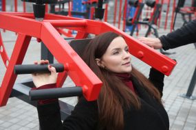 The woman trains on the street exercise machine in the territory of the Open sports space of NSC "Olympic"