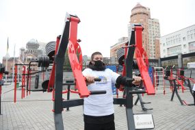 The man trains on the street exercise machine in the territory of the Open sports space of NSC "Olympic"