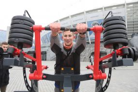The teenager trains on the street exercise machine in the territory of the Open sports space of NSC "Olympic"